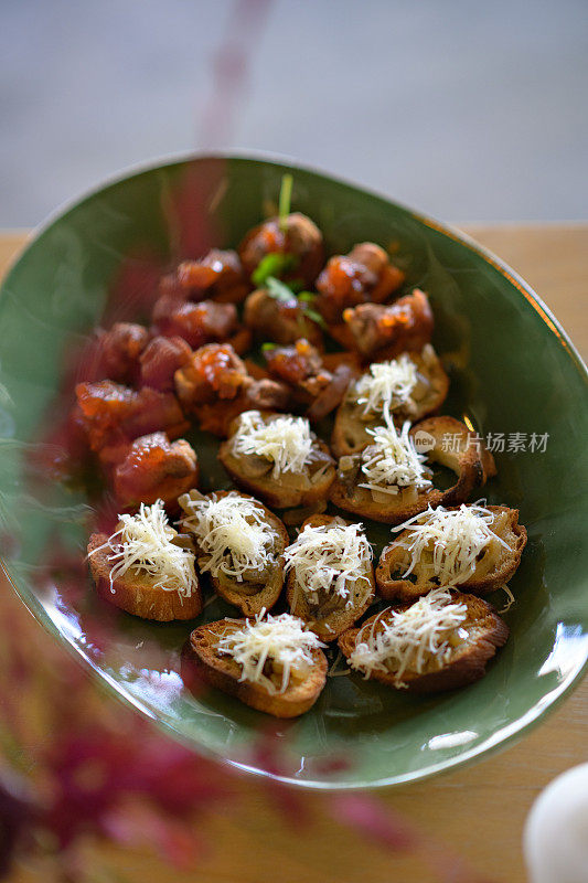意式烤面包配蘑菇芝士番茄在餐盘上的tapas canapés